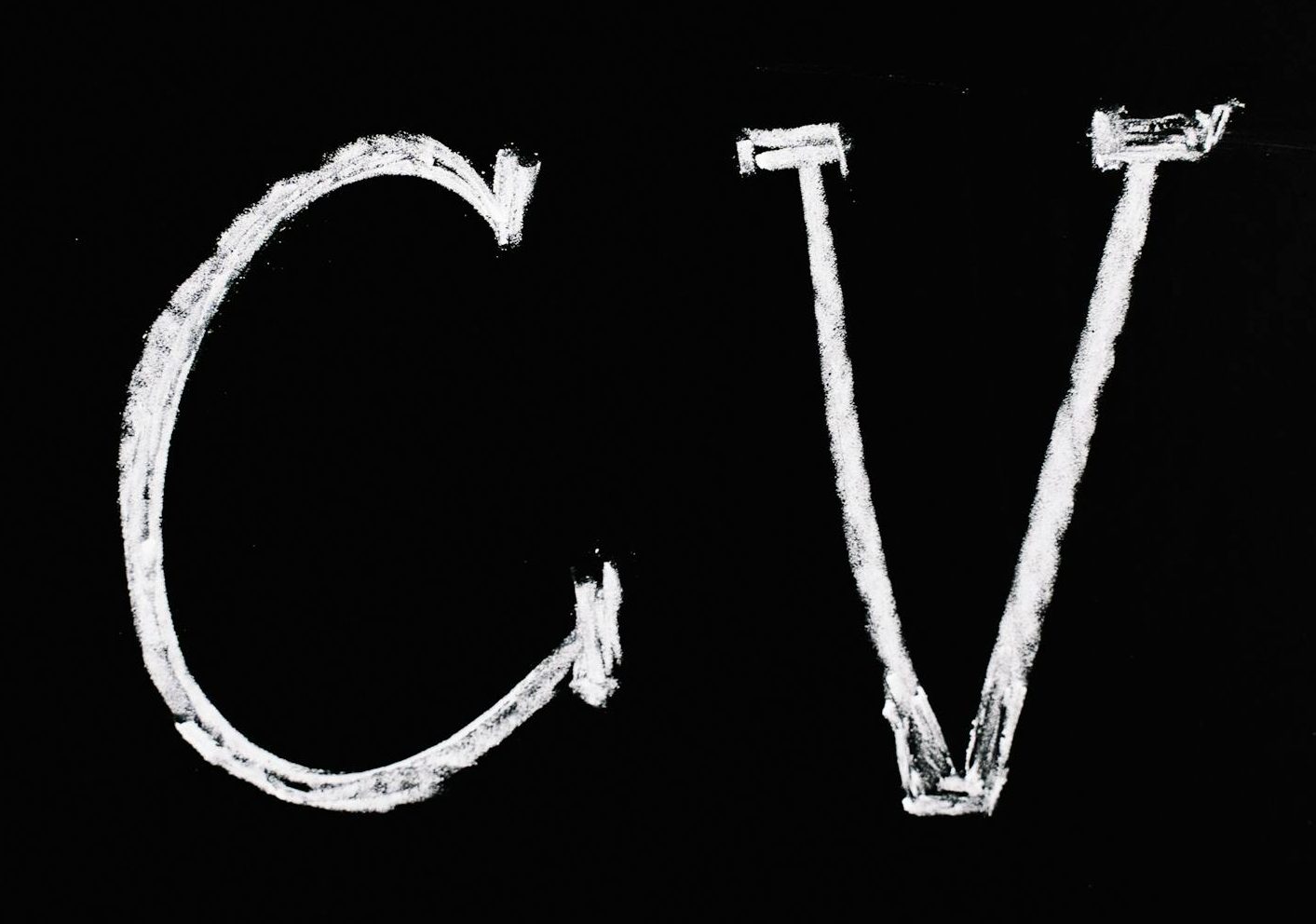 Chalk text 'CV' on a black chalkboard. Ideal for resume or education-related themes.